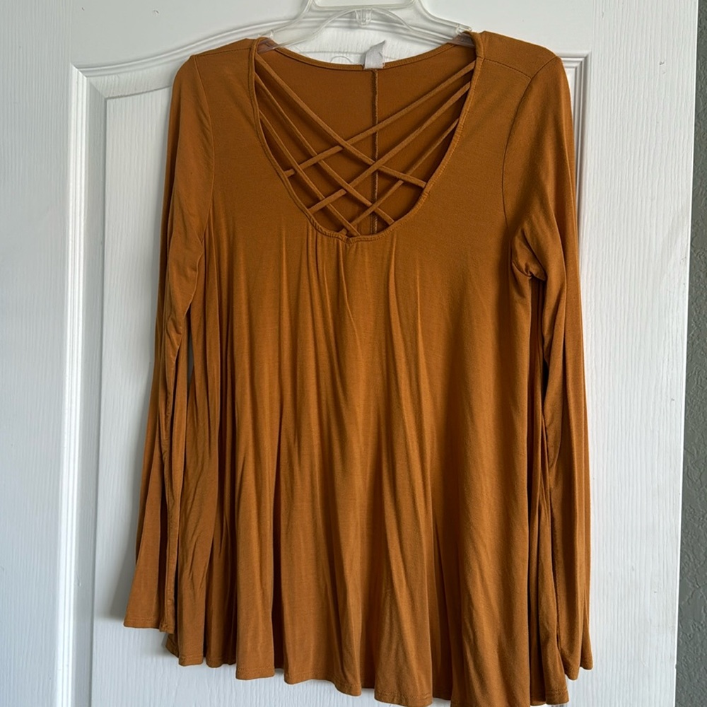 Long sleeve scoop neck tee with cross crossing on chest.